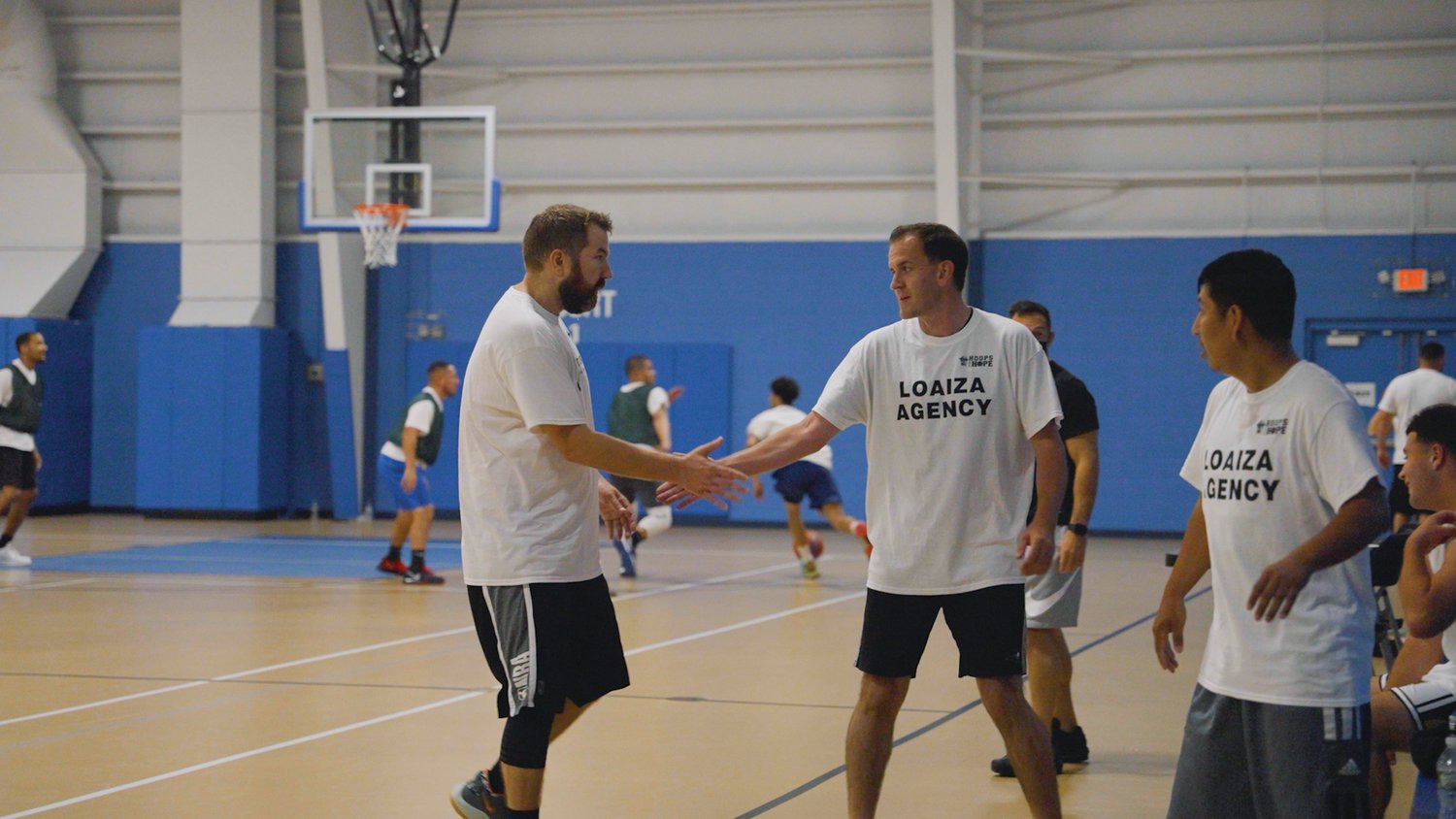 HIGH FIVE: Matthew Patty, co-founder of Sept. 18’s Hoops for Hope charity basketball tournament, slaps hands with opponent Paul Giblin as teammate Rich Saban looks on. Hoops for Hope, which was held at the Indoor Recreation Center in Johnston, raised a total of $6,000 for local causes.